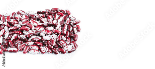 Pile of ripe speckled kidney Anasazi beans, with vivid burgundy color on white background with space for text.