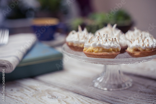 Lemon meringue pie on white wooden board with romantic decor 