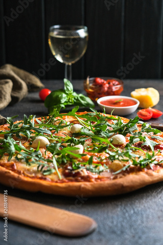 Traditional Italian pizza with wine on a dark background.