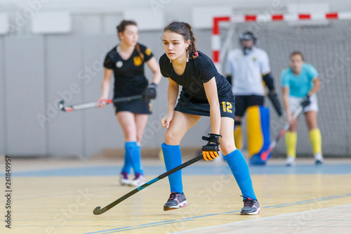 Young female indoor hockey player with stick