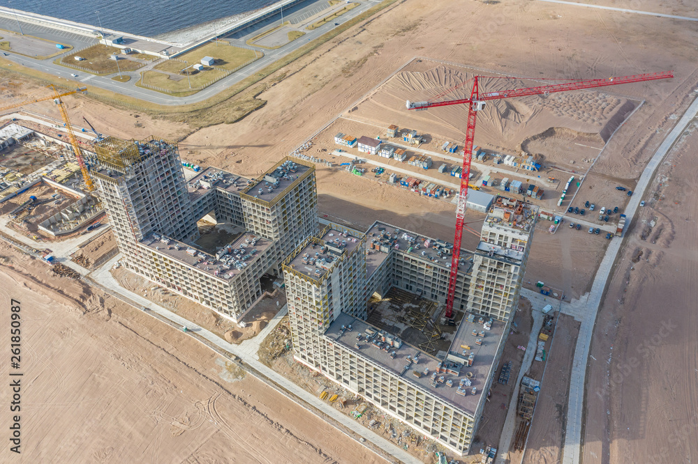 Aerial top view of high-rise residential buildings under construction and cranes.