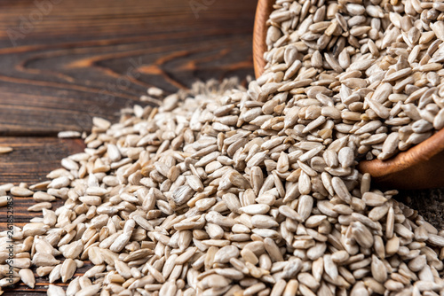 Sunflower seeds on dark wooden background.