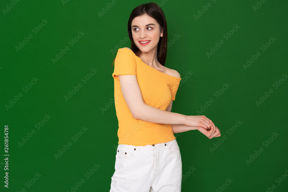 Coquettish young pretty girl isolated on green Coquettish young pretty girl isolated on green