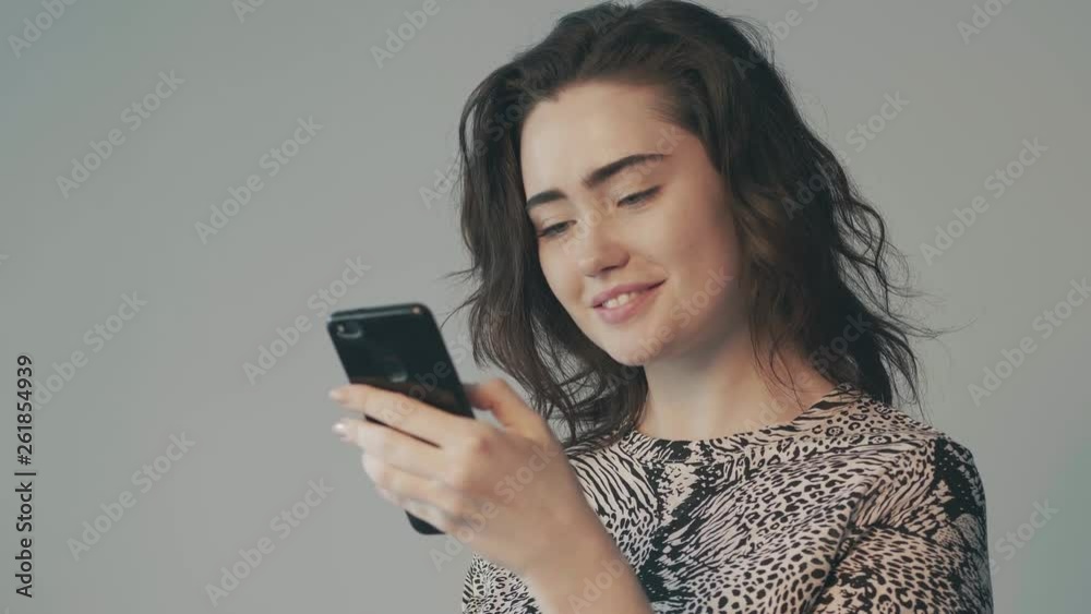 Close up portrait of beautiful woman browsing internet on her smartphone with face reaction Close up portrait of beautiful woman browsing internet on her smartphone with face reaction