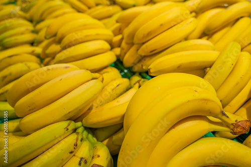 Bunch of yellow bananas on black background. Fresh and healthy. Shallow depth of field, focus on the front banana.