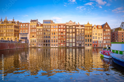 Traditional old buildings and boats at sunset in Amsterdam  Netherlands.