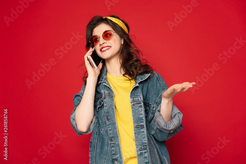 Happy hipster girl lively talking by mobile phone
