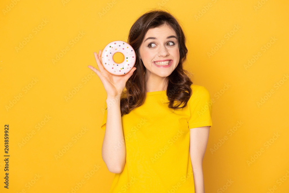 Smiling pretty girl holding sweet donut in hand Smiling pretty girl holding sweet donut in hand