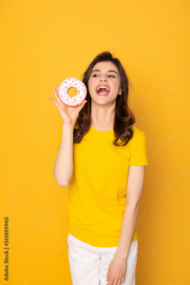 Happy excited girl holding sweet donut in hand Happy excited girl holding sweet donut in hand