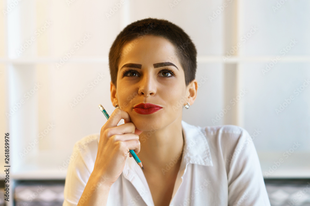 young beautiful brunette woman sit at table hold pencil in right hand young beautiful brunette woman sit at table hold pencil in right hand