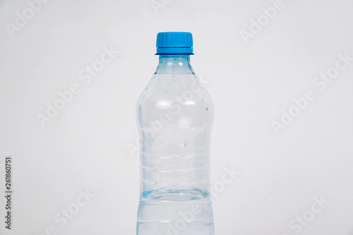 Plastic bottle with water on a light background. The concept of thirst, the desire to drink clean water. Taking care of health, proper hydration of the body.