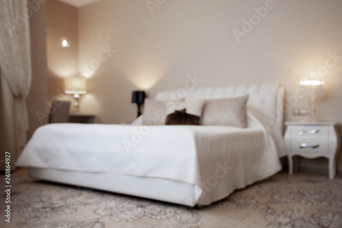 Luxury design interior of hotel room in soft brown and beige color tone. Peace and quiet. Sweet home. King size bed in the middle of the room. Blurred. Abstract. Unfocused.