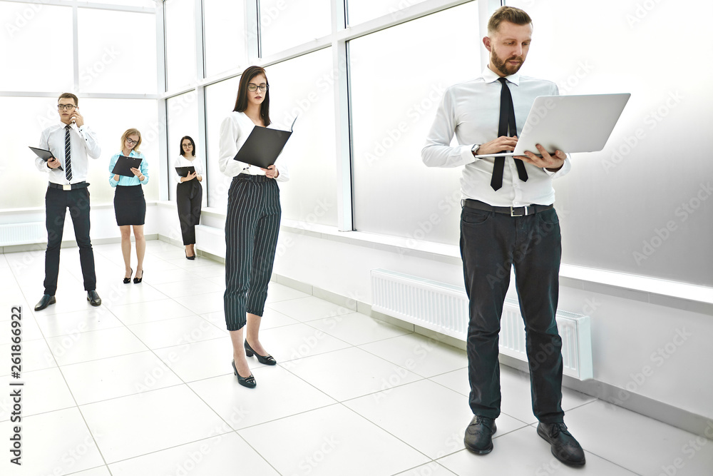 Executive employees of the company standing in the office lobby Executive employees of the company standing in the office lobby