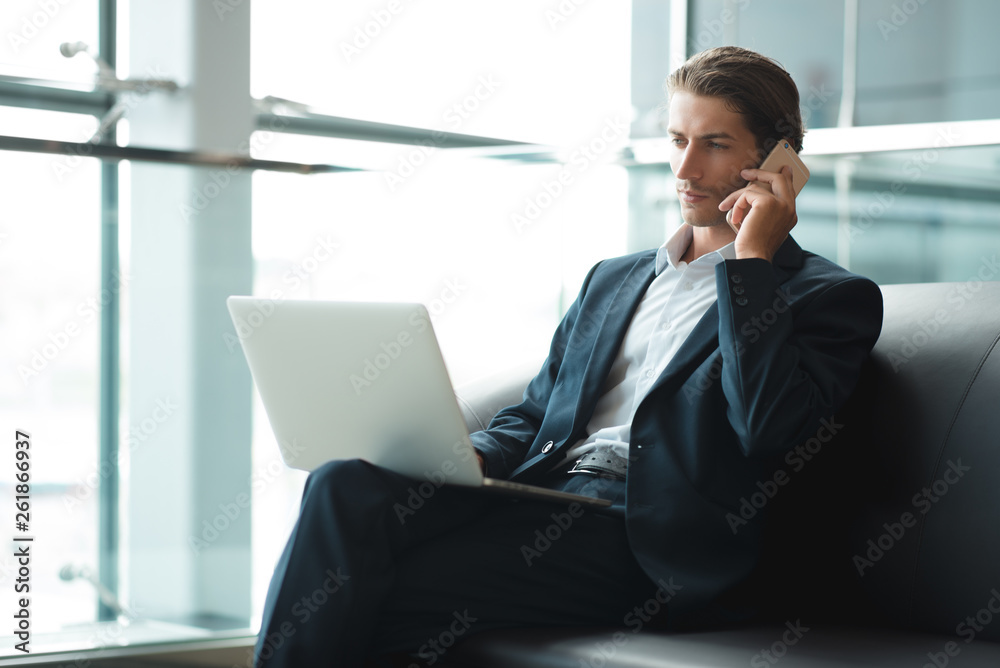 Young handsome man sitting in office with cup of coffee and working on project connected with modern cyber technologies. Businessman with notebook trying to keep deadline in digital marketing sphere. Young handsome man sitting in office with cup of coffee and working on project connected with modern cyber technologies. Businessman with notebook trying to keep deadline in digital marketing sphere.