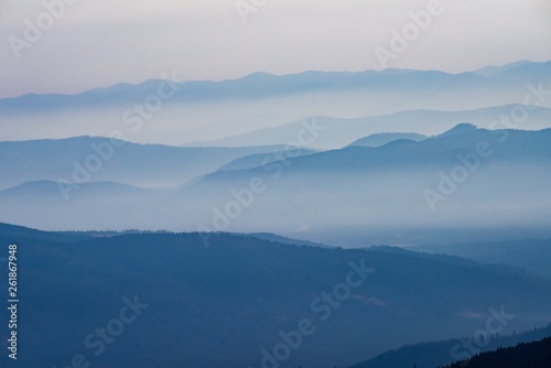 Fototapeta Naklejka Na Ścianę i Meble -  Smoke filled mountain layers in summer due to wildfires
