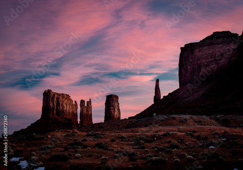 Western buttes around Monument Valley located near the border of Utah and Arizona. The Valley of The Gods national area comes to life in the soft pink glow of the morning sun light