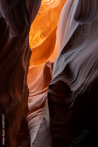 Slot canyon in Arizona with golden orange contrasted walls. This medium shot was taken while the mid-day sun spilled into the sandstone walls from the desert above