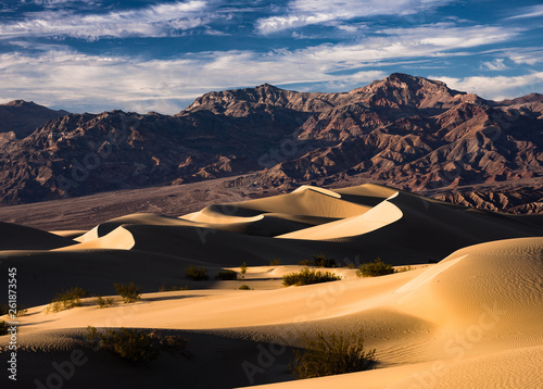 Death Valley national Park Sand Dunes at sunrise. This image was captured in the hot desert of southern California of a clear day. The sandy hills contrast the barren mountains in the background