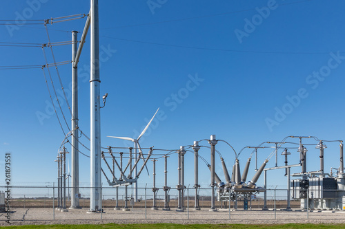 electrical substation with a wind turbine in background supplying the power