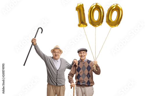 Happy senior men with a golden number hundred balloon photo