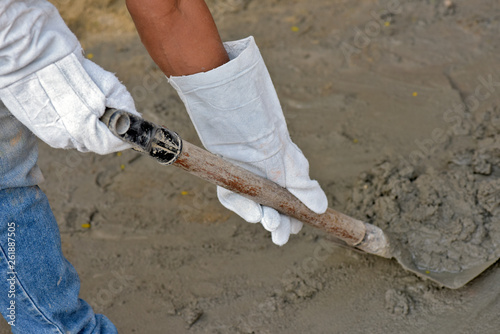 Mason holding a shovel, with protective gloves, PPE