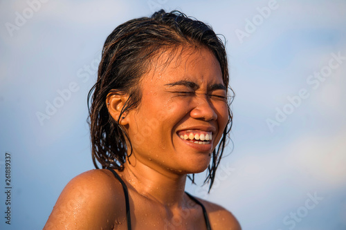 young beautiful and sexy Asian girl in bikini with wet hair enjoying holidays at tropical beach posing cool laughing happy at the sea in exotic beauty concept