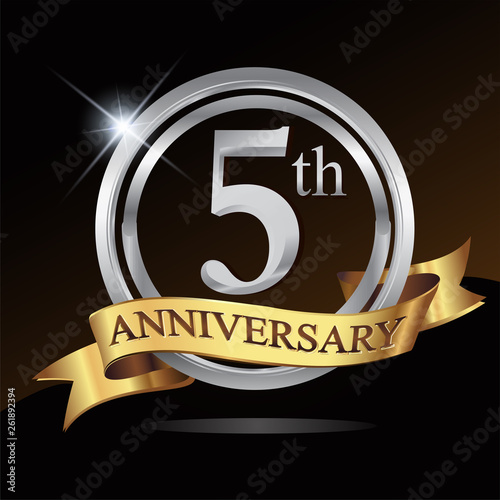 5th anniversary logo, with shiny silver ring and gold ribbon isolated on black background. vector design for birthday celebration.