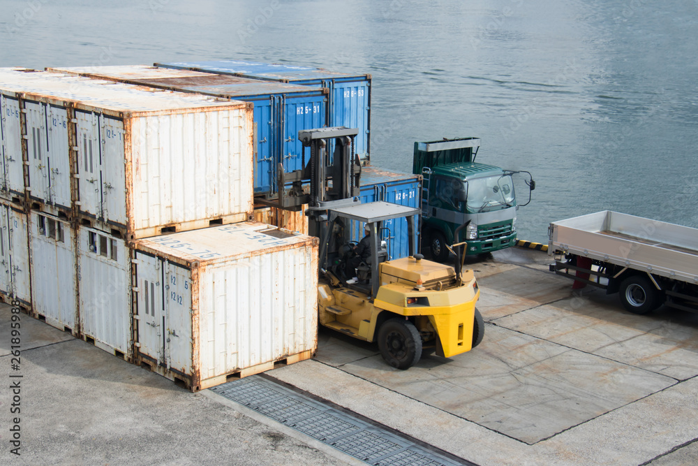 Naklejka premium A forklift that carries and organizes containers
