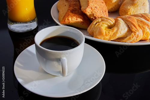 Breakfast. Coffee white cup  plate with bread croissants on dark table