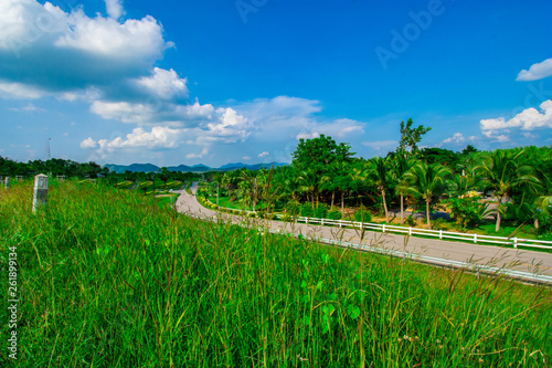 street view with green mountain on blue sky background in the province of Thailand. decoration image contain certain grain noise and soft focus.