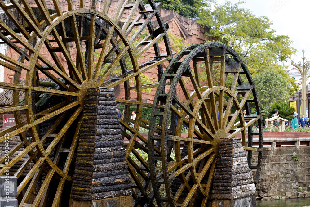 Wooden wheel of a water mill  in a square of the ancient city of Lijiang, Yunnan, China