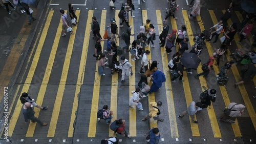 View down to crosswalk throng crowdy people flow crossing the street in peak hour