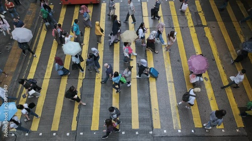 View down to crosswalk throng crowdy people flow crossing the street in peak hour