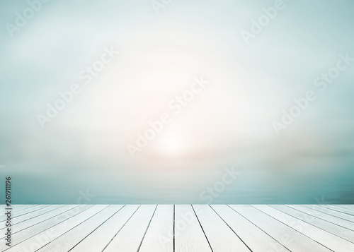The blur cool sea background with wood floor foreground on horizon tropical sandy beach.