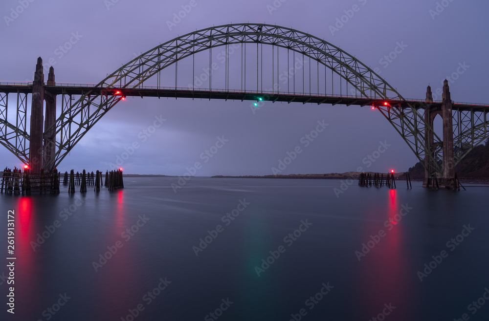 Cool metal bridge with colorful light reflections on the river surface before Sunrise in Newport, Oregon 