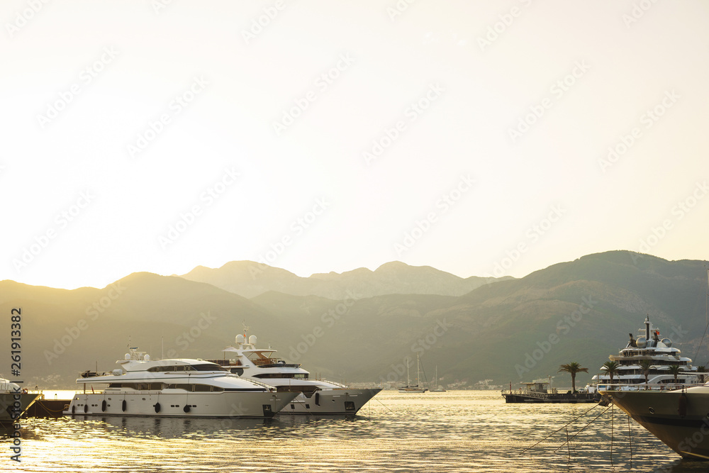 Obraz premium Vacation wallpaper with sea and yachts. Luxury sea expensive multi-deck yacht moored on the pier.