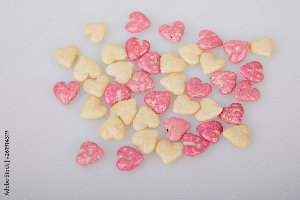 Fototapeta premium Mix of glazed, dry, pink and white heart shaped cereals breakfast on white background
