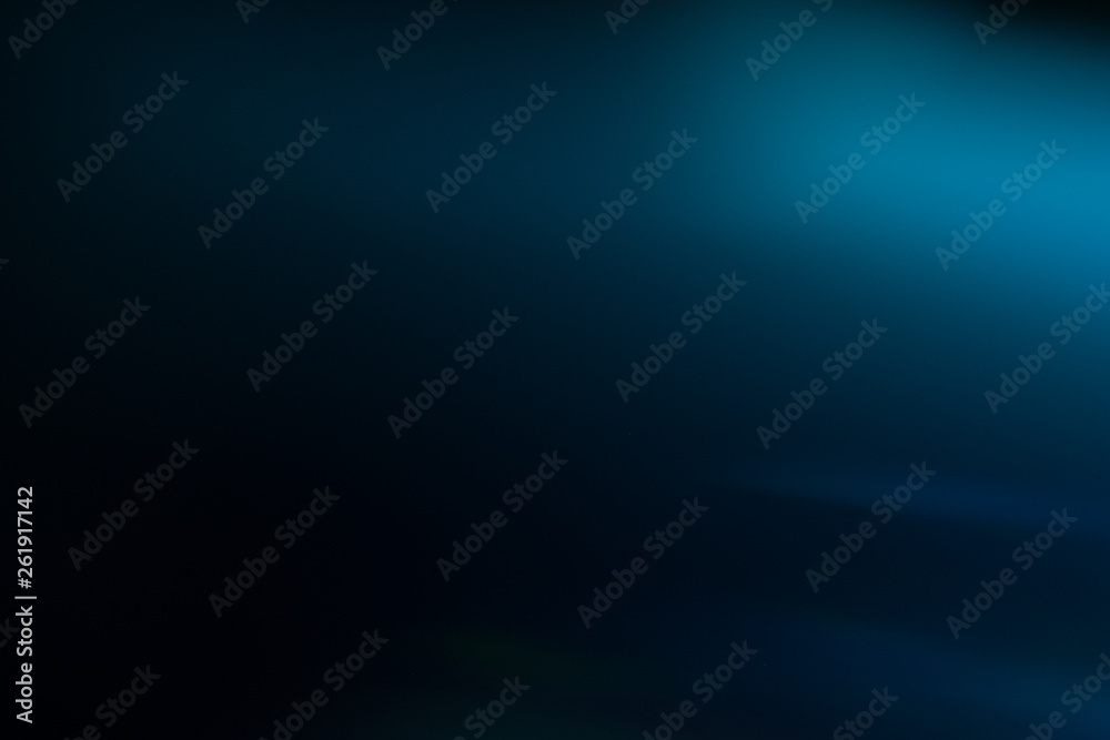 Lens flare effect. Soft defocused blurred light shine on dark blue background