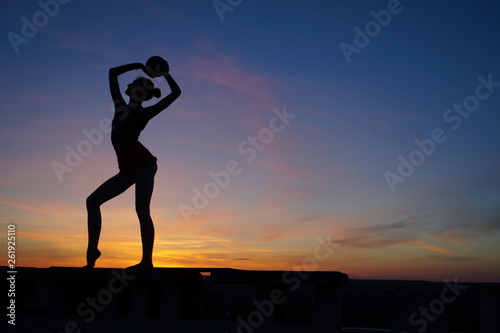 Fototapeta Naklejka Na Ścianę i Meble -  dancer in the dance does the splits in the air against the sunset.