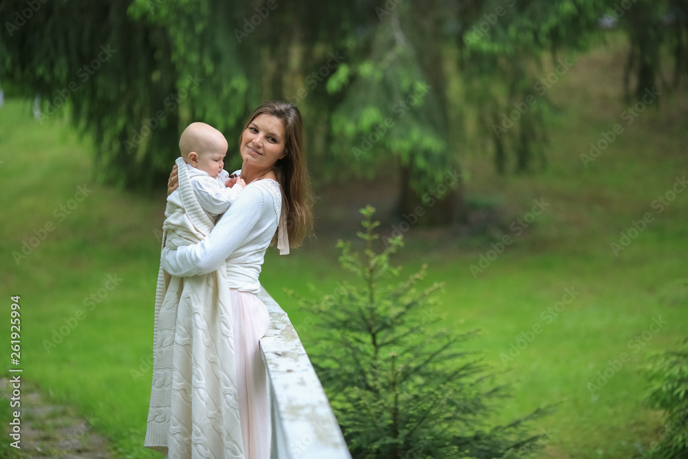 beautiful mother in a long dress hugging his son on a wooden bridge in the forest bridge beautiful mother in a long dress hugging his son on a wooden bridge in the forest bridge