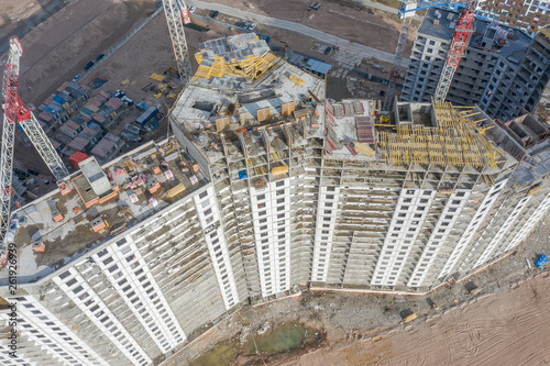 Aerial top view of high-rise residential buildings under construction and cranes.