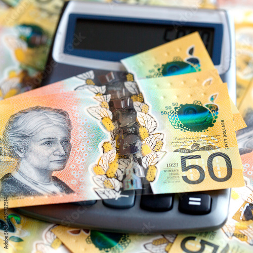 Australian fifty dollar bill over a calculator. The new 2019 issue is designed to deter counterfeiting, the note is polymer and water resistant with a clear holographic strip. photo