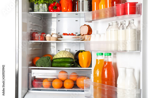 Modern fridge with fresh products on white background, closeup