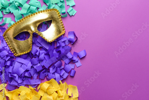 Festive mask with confetti on color background