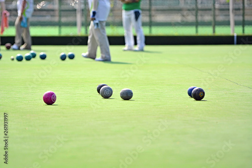 Ladies playing lawn bowls. Soft focus on the green blurred background
