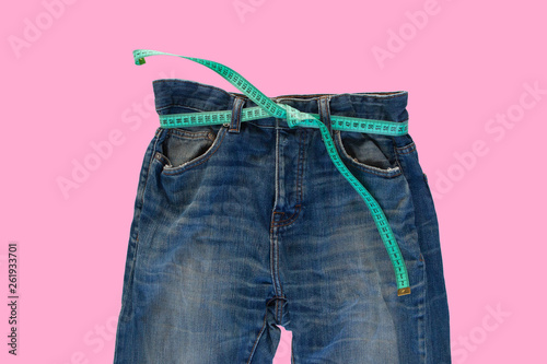 Jeans with a measuring tape. Weight loss concept photo