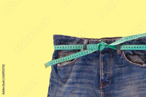 Jeans with a measuring tape. Weight loss concept photo