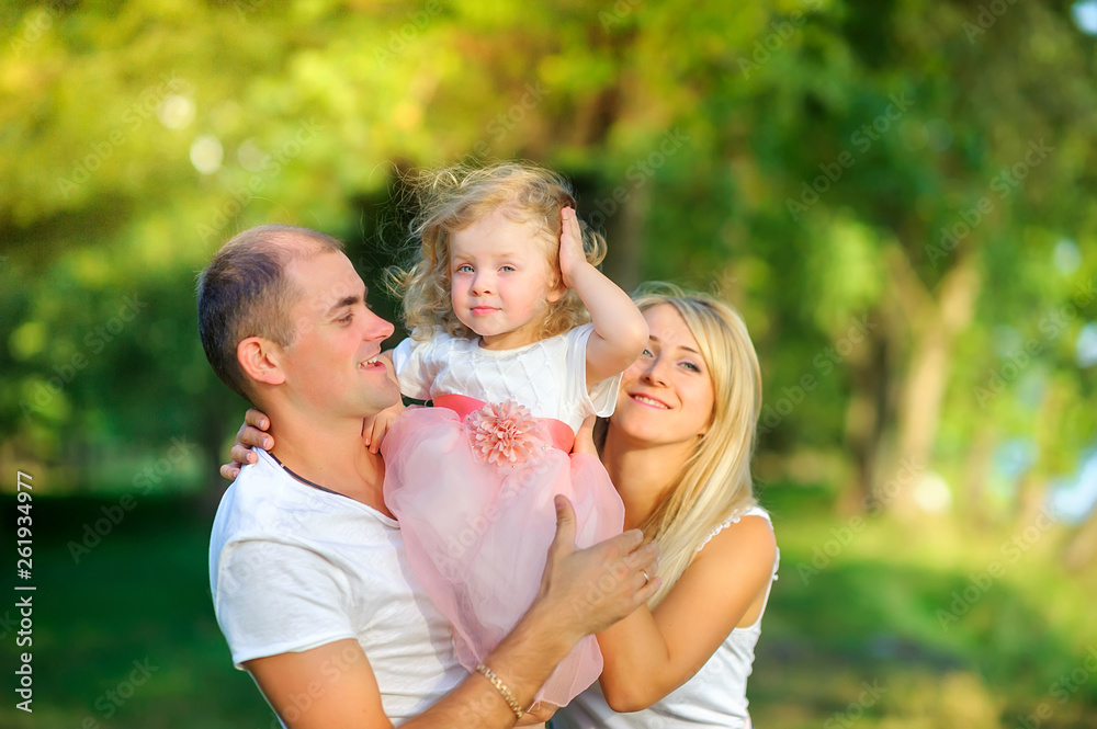 Fototapeta premium Loving family . Happy young family spending time together having fun in summer park, people concept. Family еnjoying time together