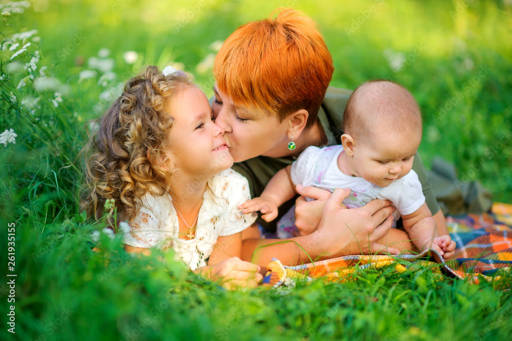 Loving family. Mom with her daughters in a beautiful park. people concept. Family enjoy time together Loving family. Mom with her daughters in a beautiful park. people concept. Family enjoy time together