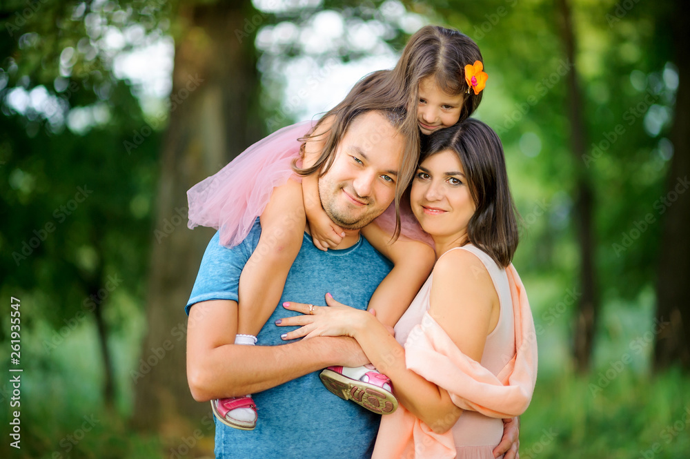 Fototapeta premium Loving family. Happy young family spending time together having fun in summer park, people concept. Family еnjoying time together